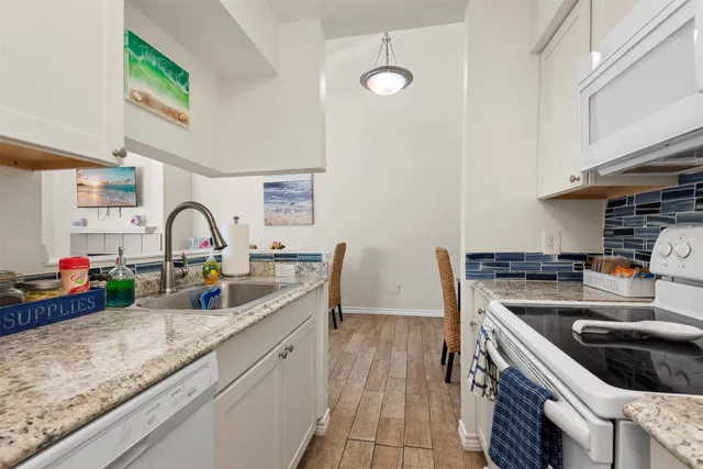 a kitchen with sink a stove and cabinets