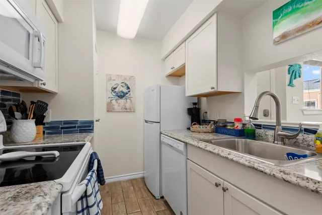 a kitchen with granite countertop a sink stove and cabinets