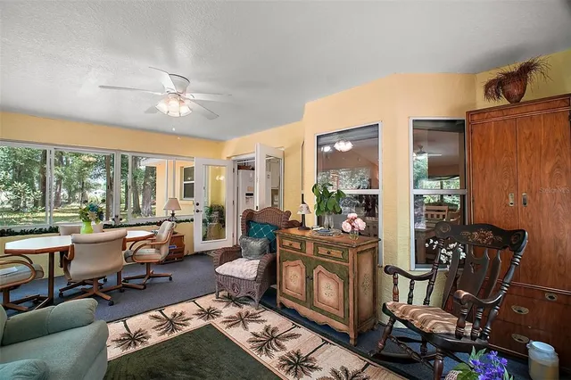 a living room with furniture fireplace and large windows