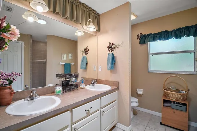 a bathroom with a granite countertop double vanity sink and a mirror