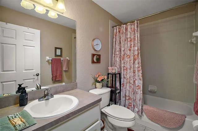 a bathroom with a sink a toilet a mirror and shower