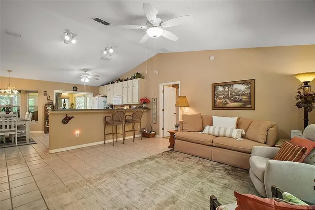 a living room with furniture a ceiling fan and a rug