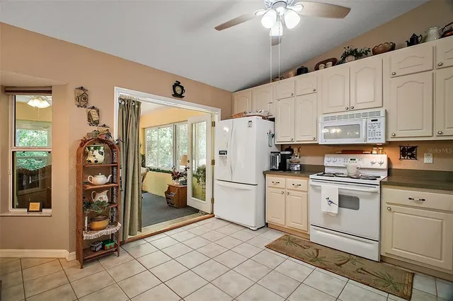 a kitchen with white cabinets and white appliances