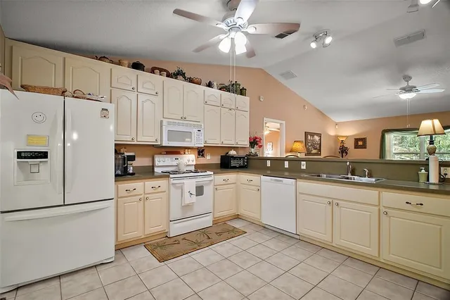 a kitchen with white cabinets and white appliances
