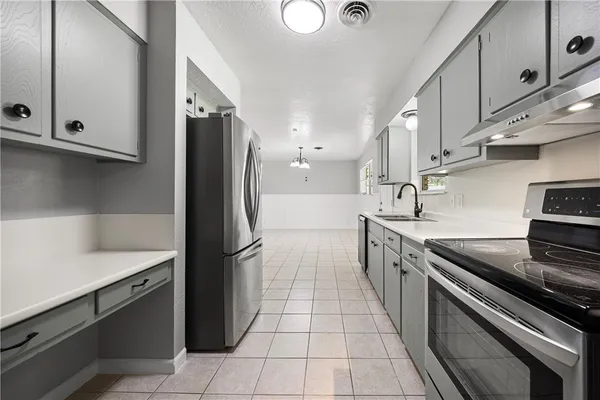 a kitchen with stainless steel appliances granite countertop a sink stove and refrigerator