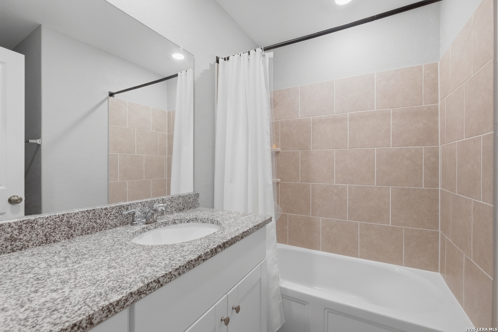 31589 Untrodden Way Bulverde, TX 78163 - Photo 21 of 26 a bathroom with a granite countertop sink a mirror and a bathtub