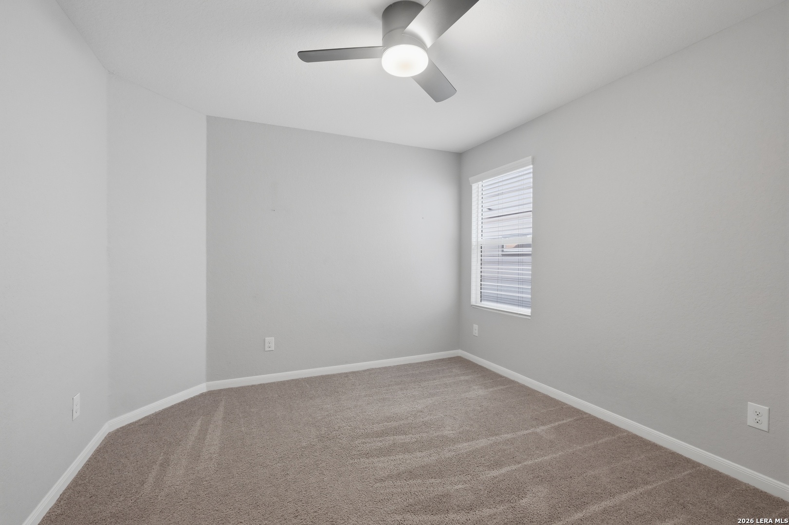 31589 Untrodden Way Bulverde, TX 78163 - Photo 22 of 26 an empty room with a chandelier fan and windows
