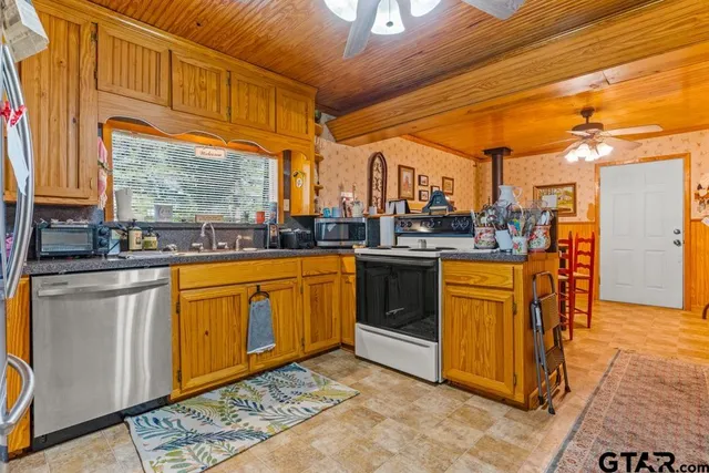 a kitchen with stainless steel appliances granite countertop a sink a stove and a refrigerator