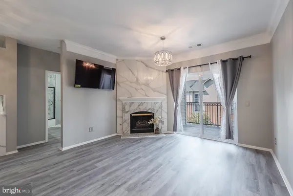 an empty room with windows fireplace and wooden floor