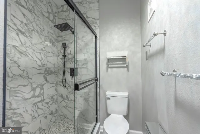 a view of a hallway with wooden floor and a chandelier