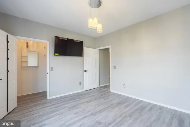 a view of a hallway with wooden floor and a chandelier