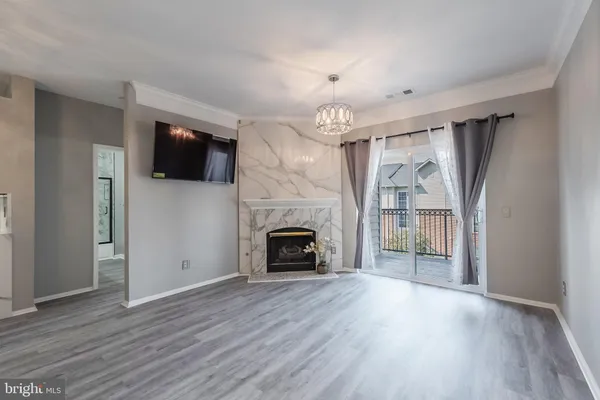 an empty room with windows fireplace and wooden floor