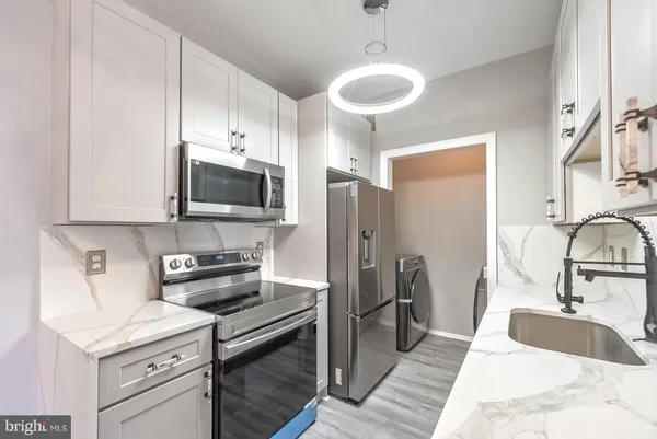 a kitchen with stainless steel appliances a sink stove and refrigerator