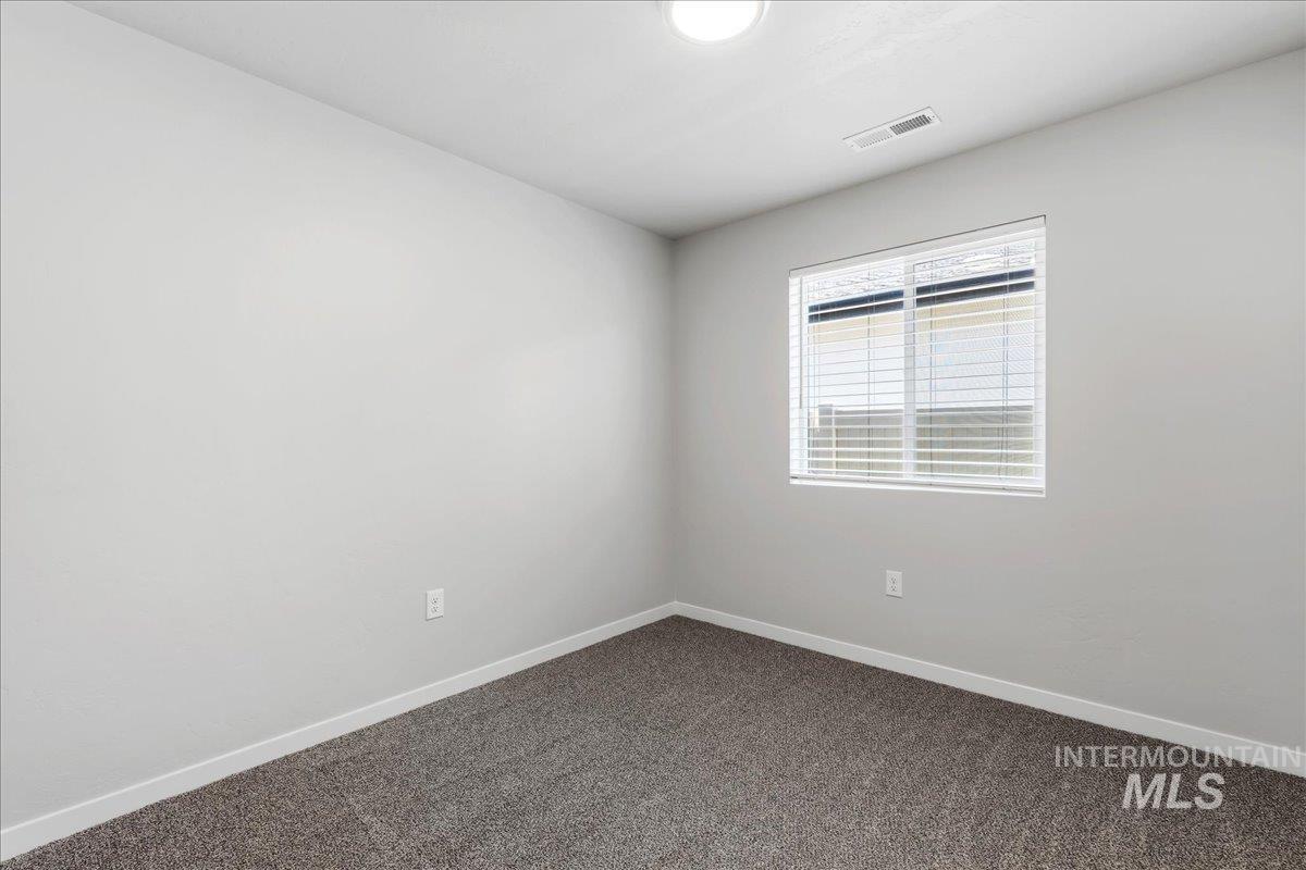 3091 S Green Boise, ID 83709 - Photo 14 of 27 Neutral-toned room featuring a single window with blinds, light gray walls, and dark gray carpeting