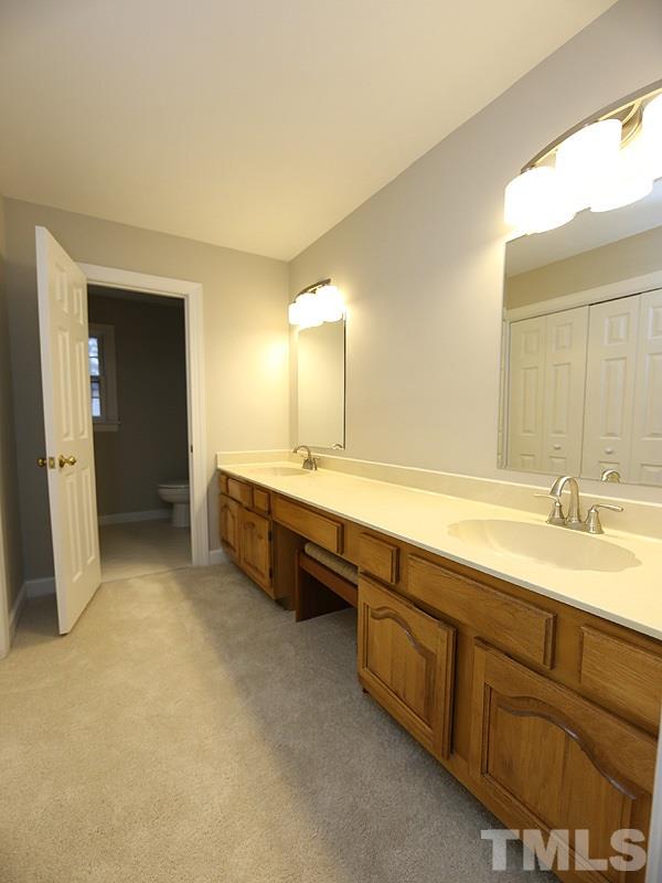 11957 Eagle Cliff Court Raleigh, NC 27613 - Photo 21 of 25 a spacious bathroom with a double vanity sink and a mirror