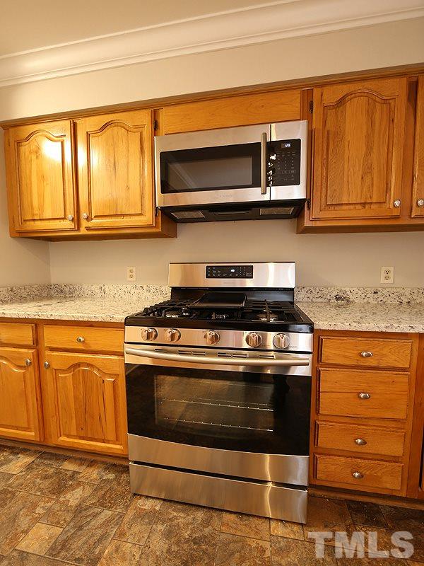 11957 Eagle Cliff Court Raleigh, NC 27613 - Photo 7 of 25 a kitchen with stainless steel appliances granite countertop a stove and a microwave