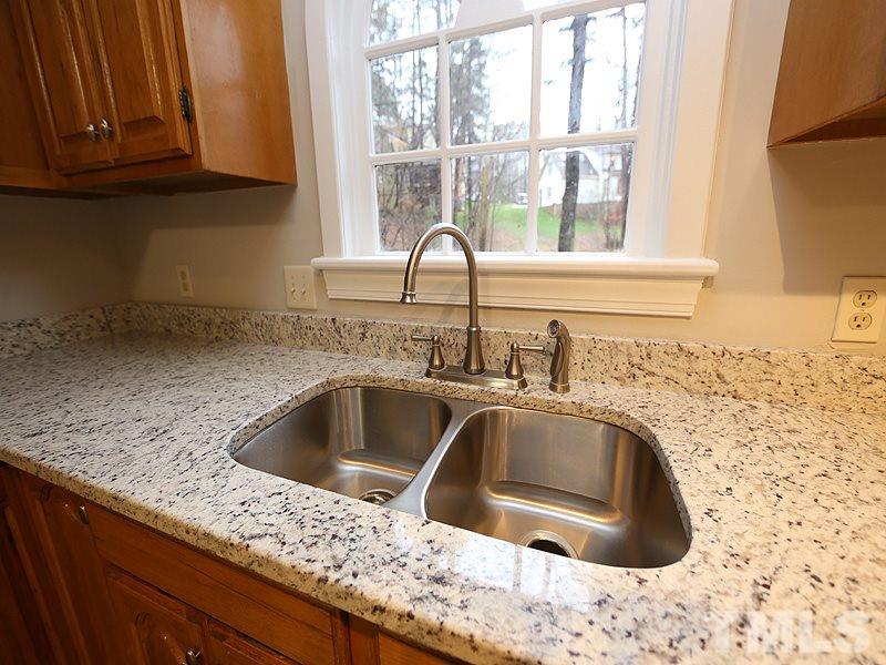11957 Eagle Cliff Court Raleigh, NC 27613 - Photo 9 of 25 a kitchen with granite countertop a sink and a window