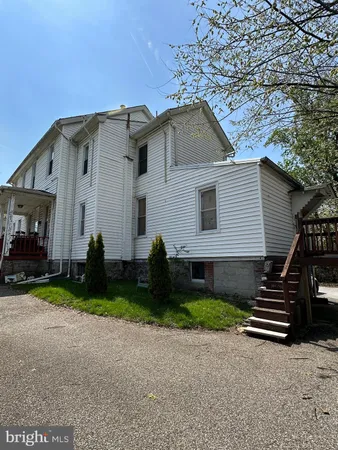 a view of a house with a yard and fence