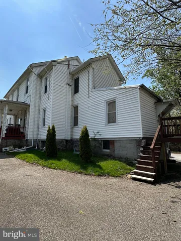 a view of a house with a yard and fence