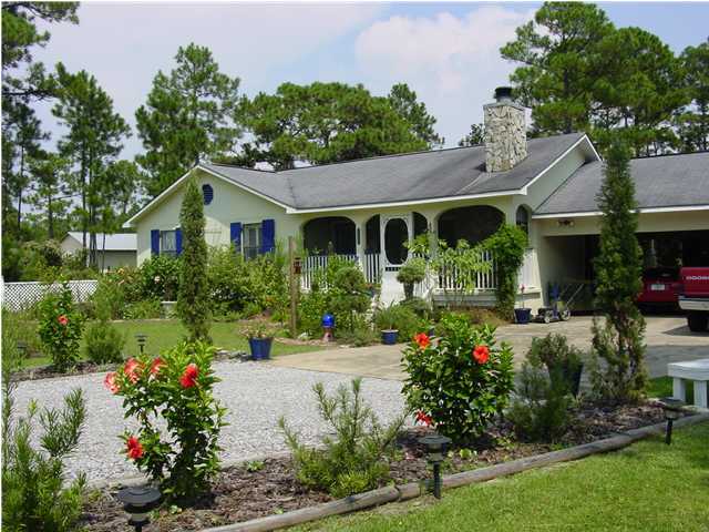 1920 Co Road North Santa Rosa Beach, FL 32459 - Photo 1 of 13 a front view of a house with a yard and potted plants