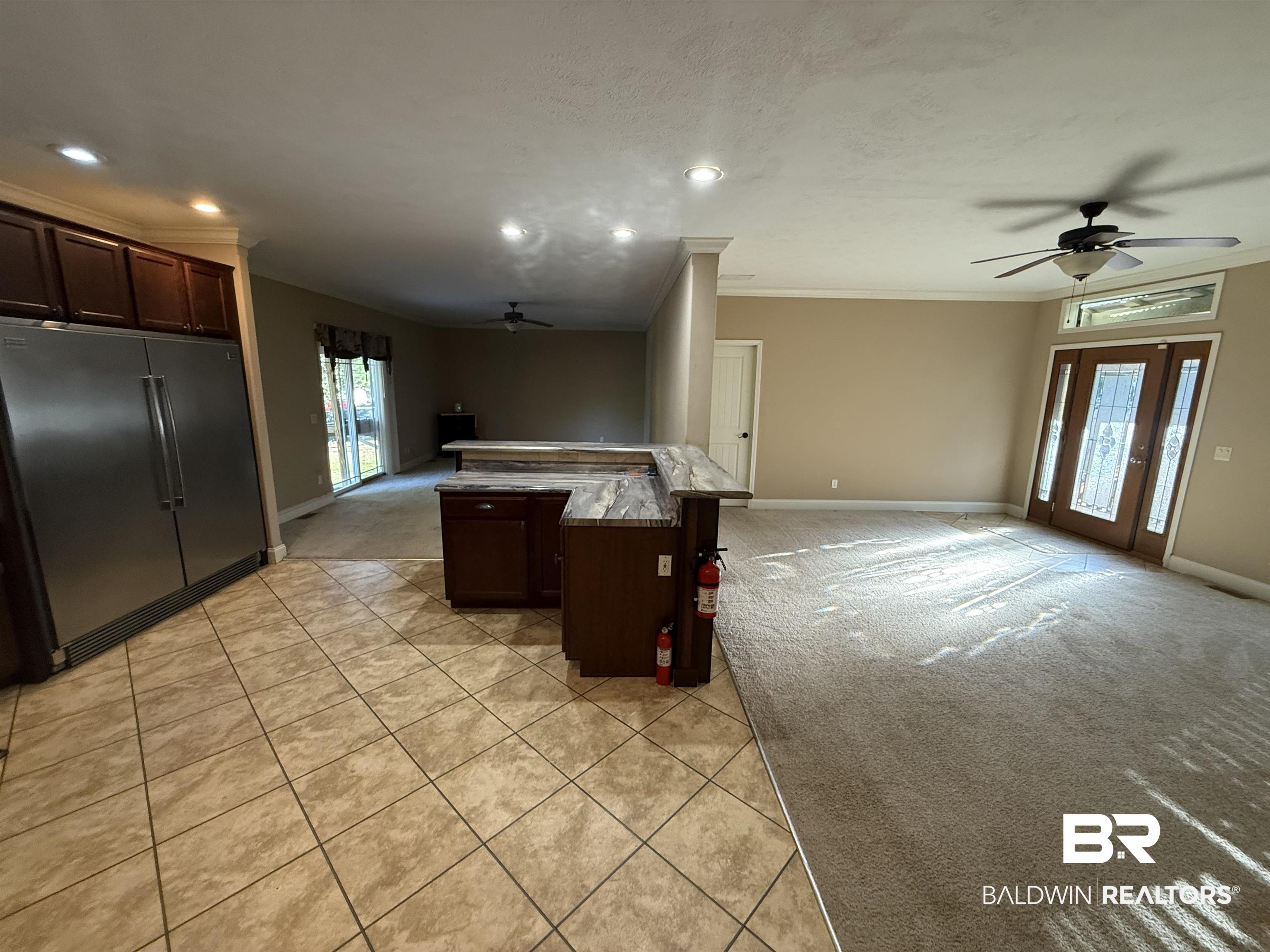 1274 Caney Loop Lillian, AL 36549 - Photo 19 of 19 Kitchen featuring dark wood finish cabinets, ceiling fan, stainless steel built in fridge, open floor plan, and ornamental molding