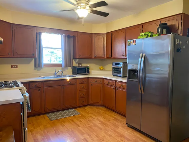 a kitchen with stainless steel appliances granite countertop a refrigerator sink and microwave