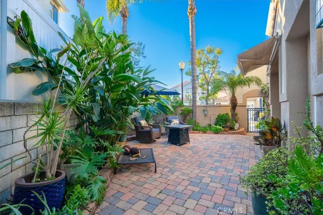 a view of a patio with plants and chairs under an umbrella