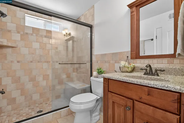 a bathroom with a granite countertop sink toilet and shower