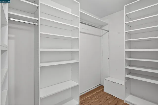 a view of walk in closet with empty racks