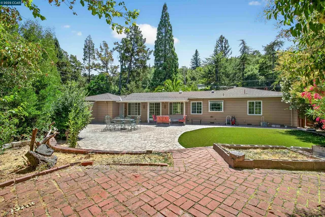 a front view of a house with a yard and trees
