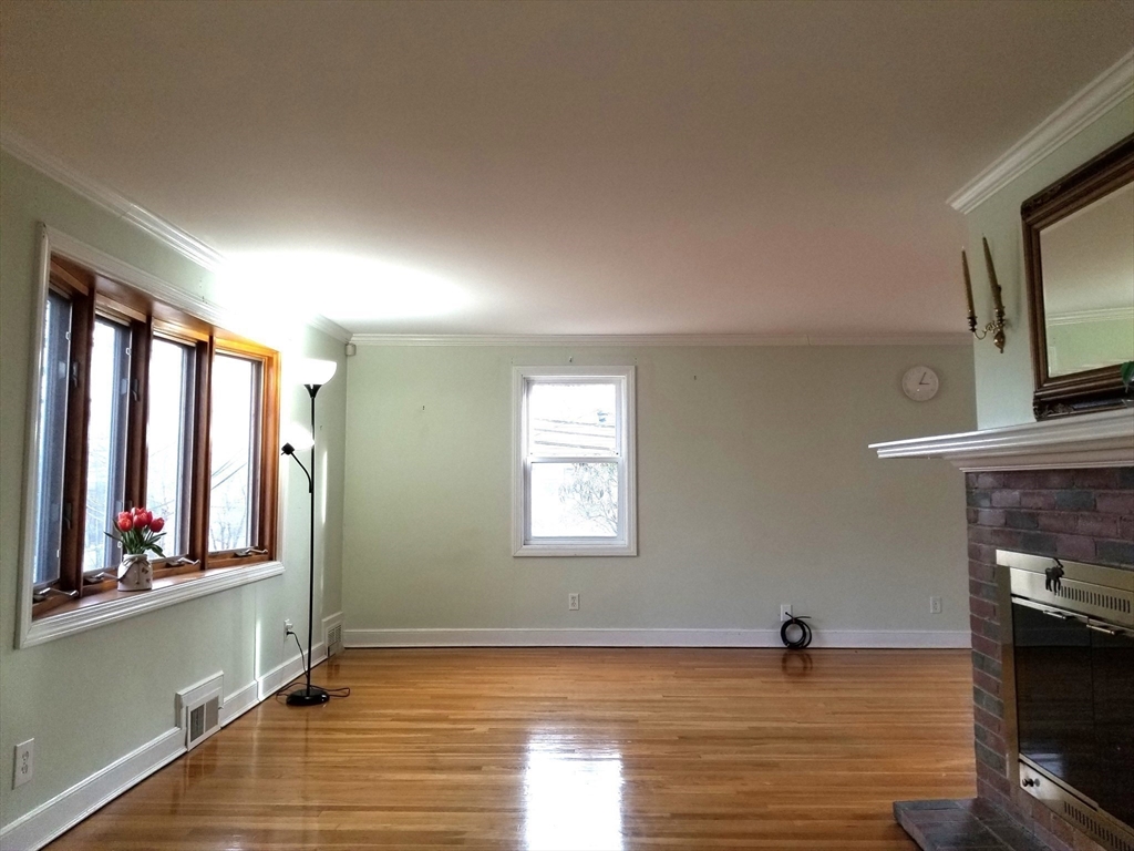 225 Governors Road, Unit 225 Quincy, MA 02169 - Photo 6 of 19 a view of an empty room with window and wooden floor