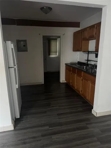 a kitchen with granite countertop a refrigerator and a sink