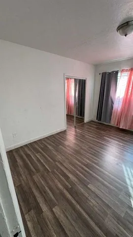 a view of an empty room and wooden floor