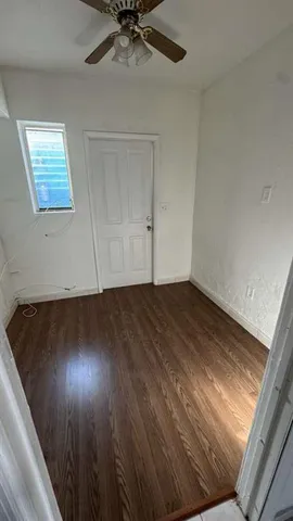 en empty room with wooden floor fan and windows