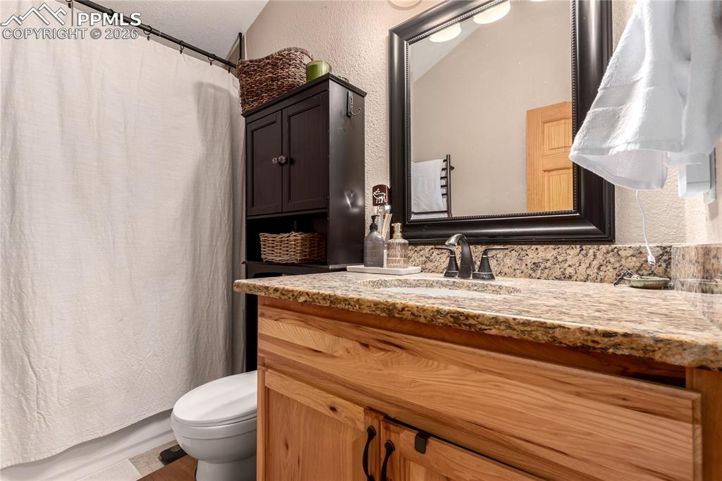 44 Anderson Road Florissant, CO 80816 - Photo 19 of 31 a bathroom with a granite countertop sink a toilet and a mirror