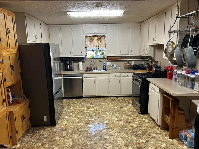 a kitchen with stainless steel appliances granite countertop a refrigerator stove sink and dishwasher