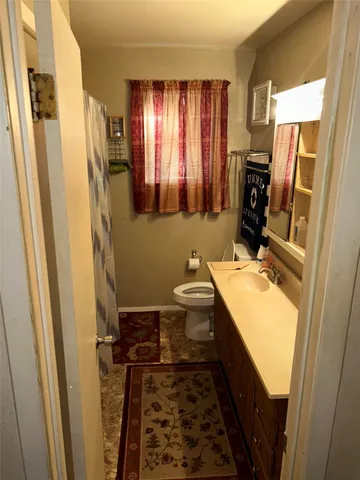 a bathroom with toilet sink and mirror