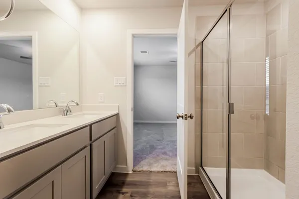 a bathroom with a shower sink and mirror