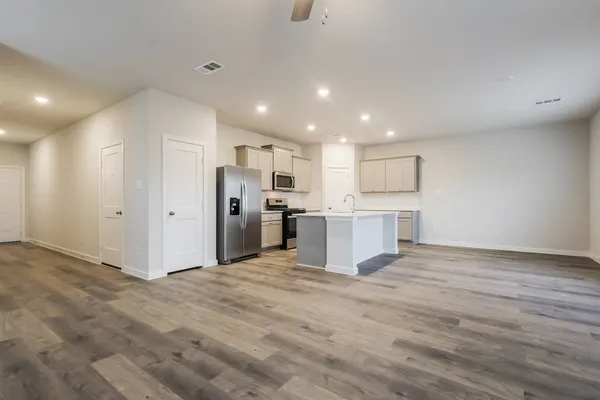 a view of a kitchen with refrigerator and white cabinets