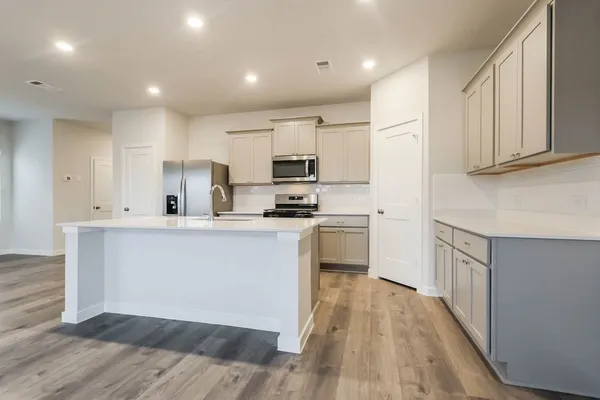 a kitchen with white cabinets and appliances