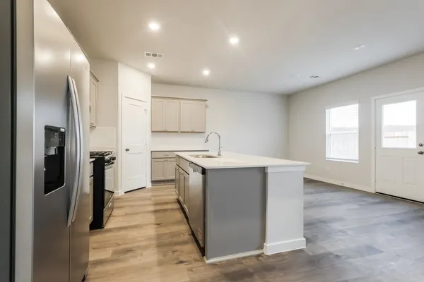 a kitchen with a refrigerator sink and cabinets