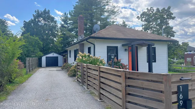 a view of a house with a yard and large tree