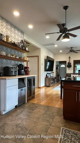 a open kitchen with stainless steel appliances kitchen island granite countertop a table chairs and a refrigerator