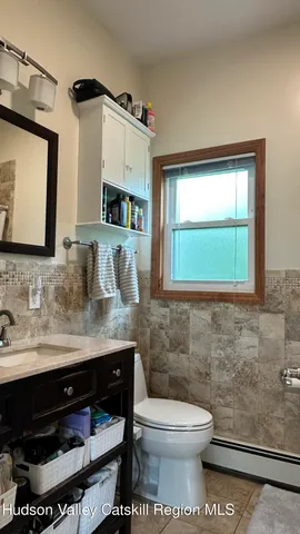 a bathroom with a toilet a sink and mirror