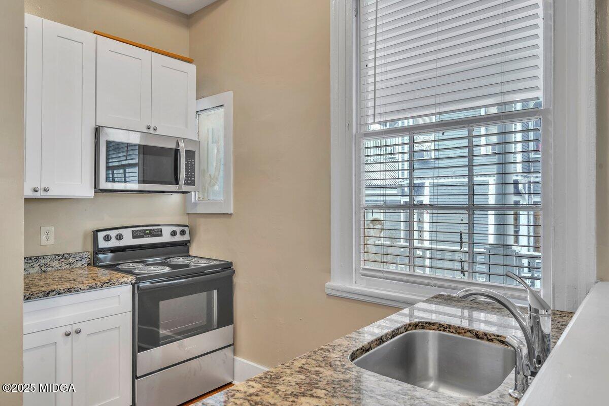 1873 Hardeman Avenue Macon, GA 31201 - Photo 11 of 25 a kitchen with granite countertop a sink and a stove