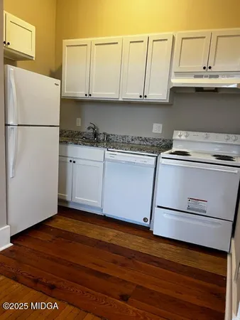 a kitchen with granite countertop white cabinets and a stainless steel appliances