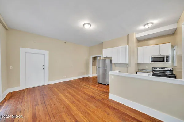 a view of a kitchen with a sink stove cabinets and empty room