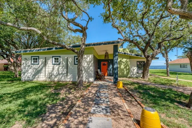 a view of a house with a yard and tree s