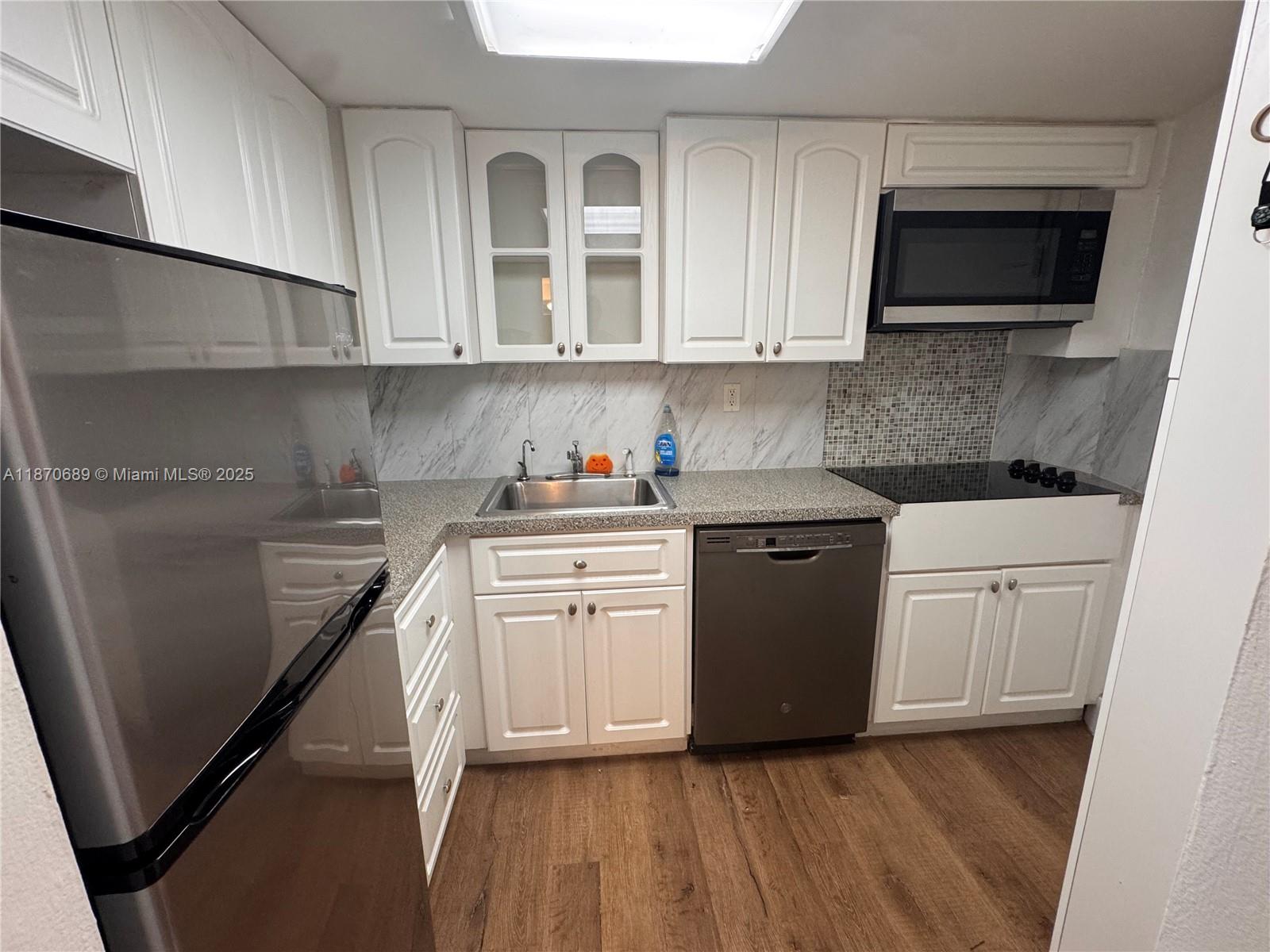 2899 Collins Avenue, Unit 1526 Miami Beach, FL 33140 - Photo 5 of 30 a kitchen with white cabinets stainless steel appliances and sink