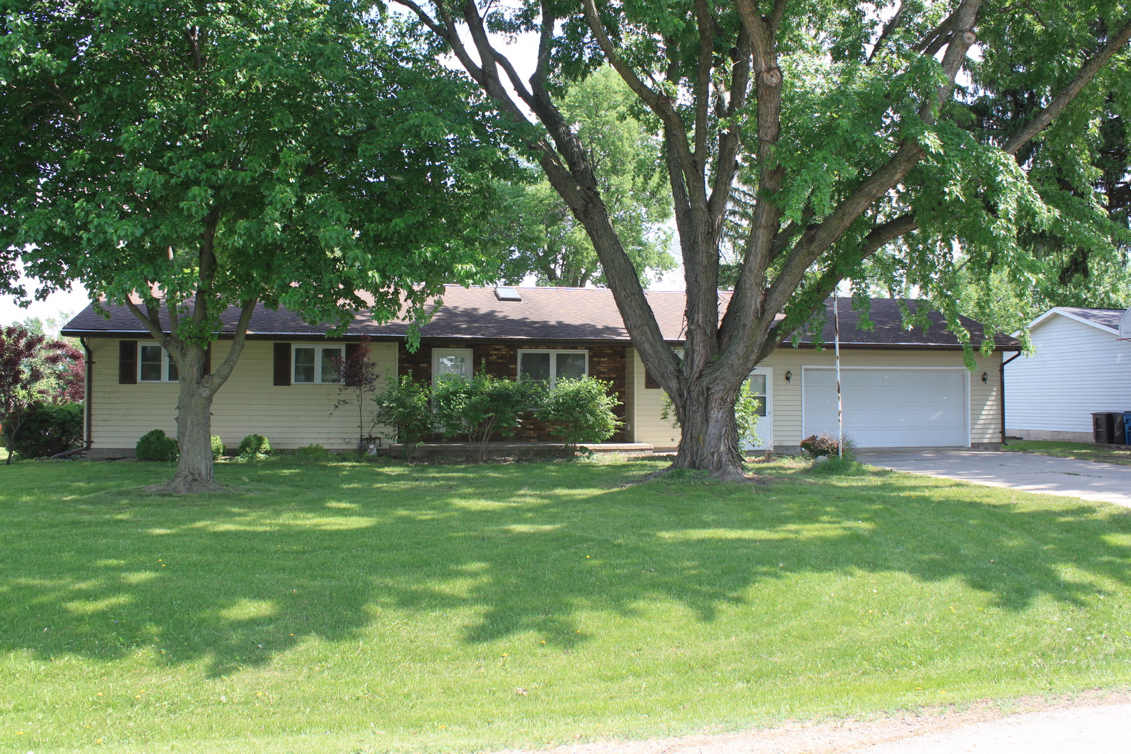 12892 Lawrence Road Sterling, IL 61081 - Photo 1 of 29 a front view of a house with a garden and trees